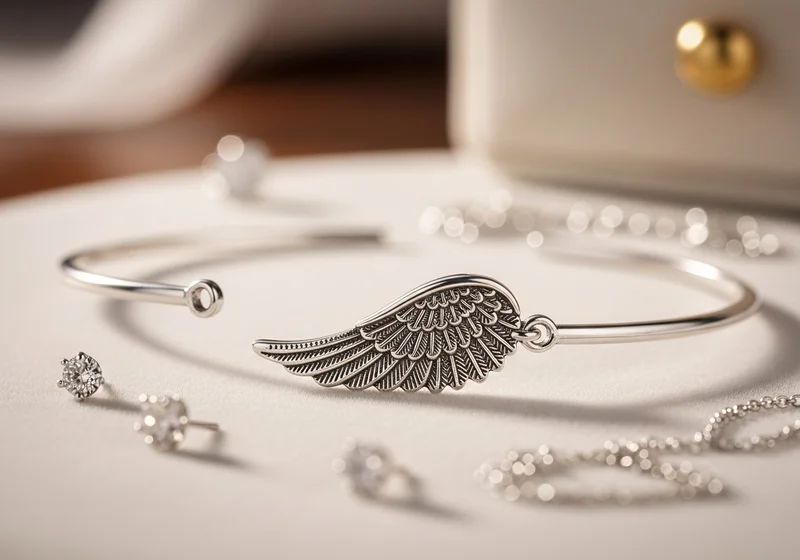 Srebrna bransoletka z motywem skrzydła, dookoła kolczyki i łańcuszki na tle szkatułki.